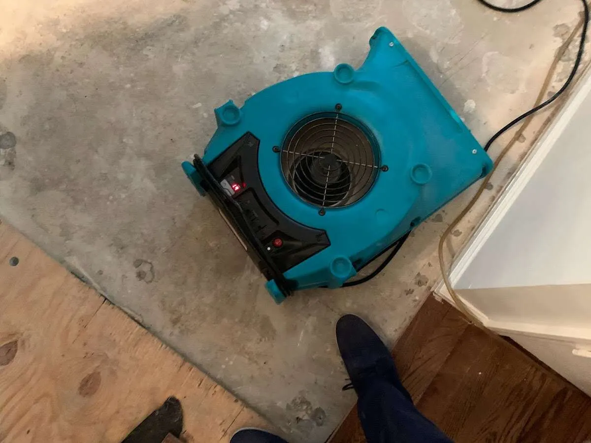 Air mover drying subfloor during Commercial Water Damage Restoration in Charlestown